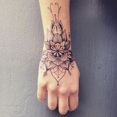 a woman's hand with a flower tattoo on the left side of her arm