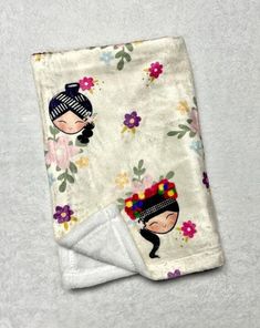 a white towel with an image of two women on it and flowers in the background