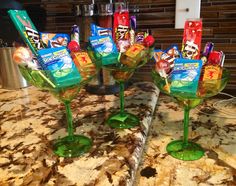 three wine glasses filled with candy on top of a marble countertop in a kitchen