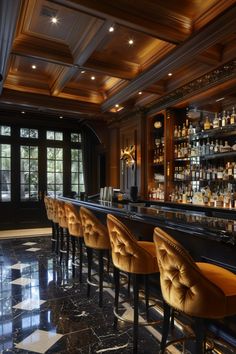 a bar with several stools and bottles on the shelves in front of it,