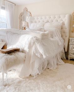 a white bed sitting in a bedroom on top of a fluffy rug next to a window