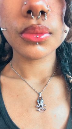 a woman with piercings on her nose wearing a necklace