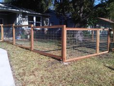 a fence that is in the grass near a house