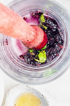 an overhead view of a blender with blueberries and other ingredients in it, including yogurt