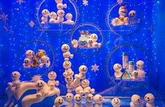 there are many snowmen on display in the store window with blue lights behind them