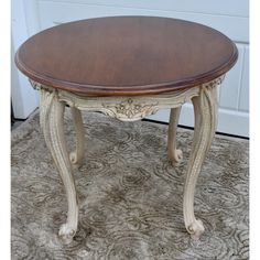 an oval wooden table sitting on top of a carpeted floor next to a white door