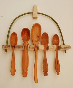 several wooden spoons hanging on a wall