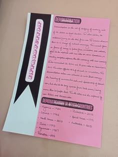 a pink piece of paper with writing on it