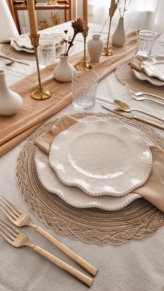 the table is set with white plates and gold cutlery, along with silverware