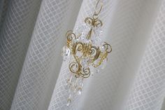 a chandelier hanging from the side of a curtain