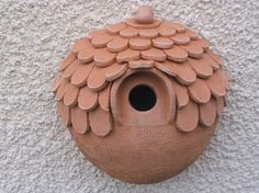 a clay birdhouse on the side of a building