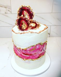 a white cake with pink and gold decorations