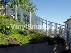 a white fence on top of a green hillside