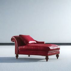 a red leather chaise lounge chair sitting on top of a white carpeted floor