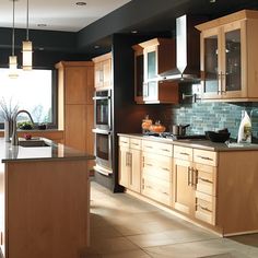 a large kitchen with wooden cabinets and stainless steel appliances, along with marble counter tops