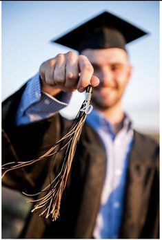 a man in a graduation cap and gown holding a tassel