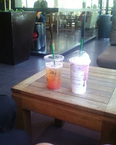 two drinks sitting on top of a wooden table