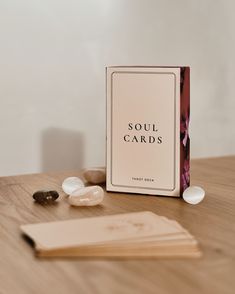 a card game sitting on top of a wooden table next to some rocks and stones