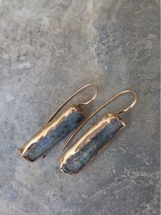 "One-of-a-kind raw Kyanite 14k goldfilled earrings with a rustic touch that will upgrade your outfit Size: > Length: 1.6\" (40 mm) > Width: 0.3\" (7.6 mm) Materials: > Sheet of 14k goldfield > Raw blue-grey kyanite gemstone Each part in these earrings is HANDMADE with a hand touch threaded, soldered, hammered, and bezel. I believe jewelry within it preserves the memories and images from specials moments in your life, Jewelry is inherited across generations and carries stories: relationships, sentiments, and frozen moments of changing cultures. Therefore, the meaning for me is eternal. Jewels deserve both care and QUALITY AND RESISTANT MATERIALS.  I'm using noble metals: gold, silver, copper, and goldfield (not gold plated). If you have any questions or special requests just send me a messa Soldered Earrings, Kyanite Earrings, Gray Gemstones, Raw Stone Earring, Hardware Jewelry, Life Jewelry, Rectangle Earrings, Precious Metal Clay, Earrings Long