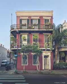 a red building with balconies and plants on it