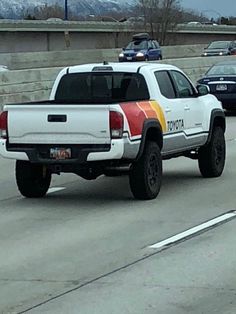 a white truck driving down a highway next to other cars