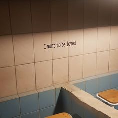 two urinals in a public restroom with the words i want to be loved written on the wall