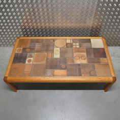 This table features a solid wooden frame that holds a top made of ceramic tiles following an earthy color pattern and geometric designs. The frame is robust and sturdy, the wood parts hardly have any wear and the ceramic tiles are in very good condition. Danish Coffee Table, Earthy Colors, Geometric Designs, Ceramic Tiles, Color Patterns, Wooden Frames, Wooden Frame, The Frame, 1960s