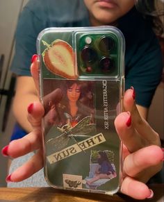 a woman holding up a cell phone case with pictures on it and the cover is clear