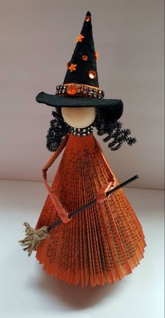 an orange fan with a witch hat and broom on it's head is shown