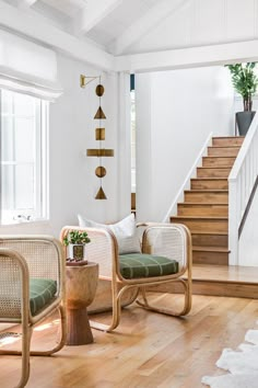 a living room filled with furniture next to a stair case and wooden floored stairs