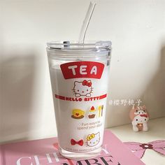 a plastic cup with a straw in it sitting on top of a pink table cloth