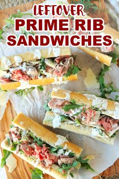 three sandwiches with lettuce, meat and cheese on them sitting on a cutting board