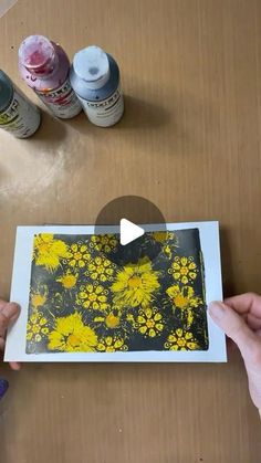 someone is painting flowers on a piece of paper with acrylic paint and watercolors