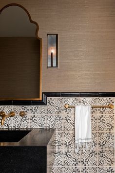 a bathroom with a sink, mirror and towel rack on the wall next to it