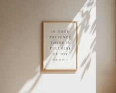 a white wall with a framed quote on it that says in your presence there is fulfillment of joy