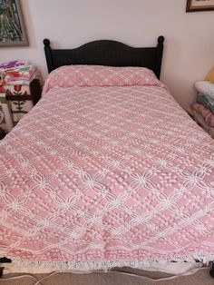 a pink bedspread with white lace on it