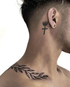 a man with a crown tattoo on his neck and behind his ear is an olive branch