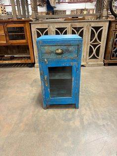 an old blue cabinet is sitting on the floor