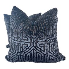 a blue and white pillow with an intricate design on the front, sitting against a white background