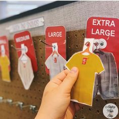 a person is holding up an extra large sticker to hang on a clothing rack