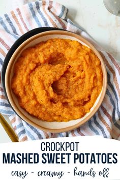 a bowl filled with mashed sweet potatoes on top of a blue and white towel