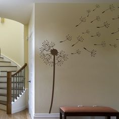 a wall with a dandelion painted on it and a bench in the foreground