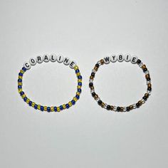 two beaded bracelets with the words corbaine and wybble written on them