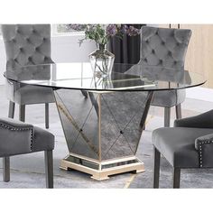 a glass table with grey chairs around it