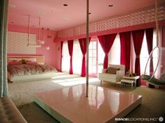 a large bedroom with pink walls and curtains on the window sill, bed in center