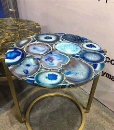 a table that has some kind of blue and white design on it, sitting in front of a wall