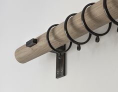 a wall mounted coat rack with five rings on it's sides and two hooks hanging from the side