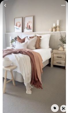 a white bed sitting in a bedroom next to two pictures