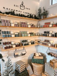 the shelves are filled with candles and other holiday decorations in baskets on wooden shelves next to christmas trees