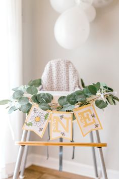 a baby's first birthday party with greenery and bunting